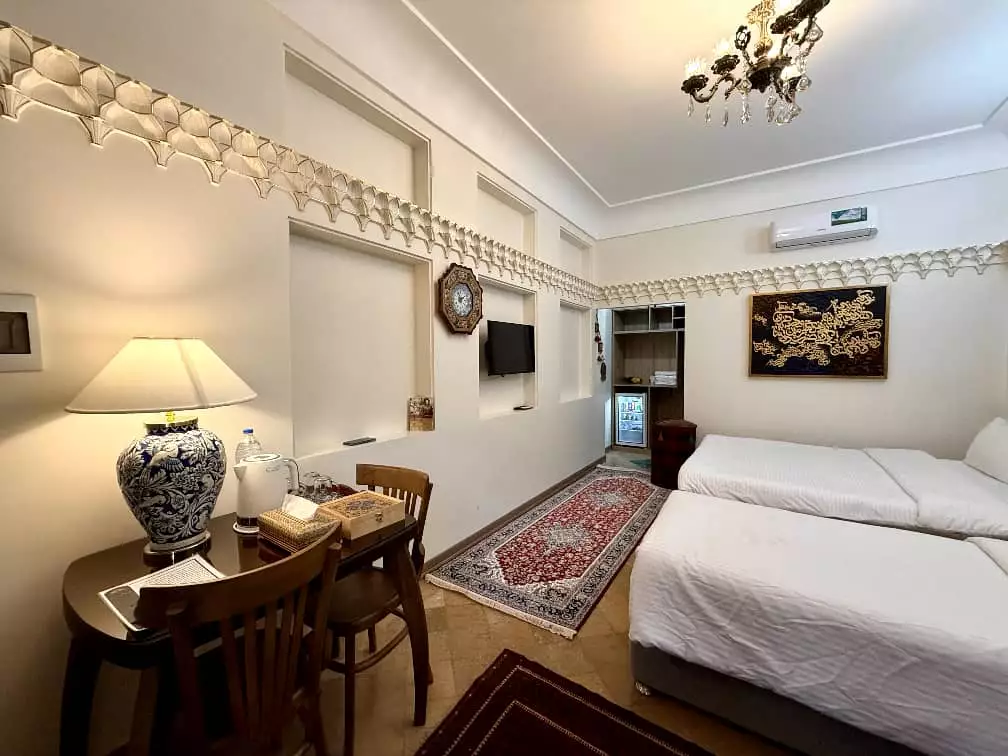 اتاق عمارت سهروردی با تخت و میز چوبی