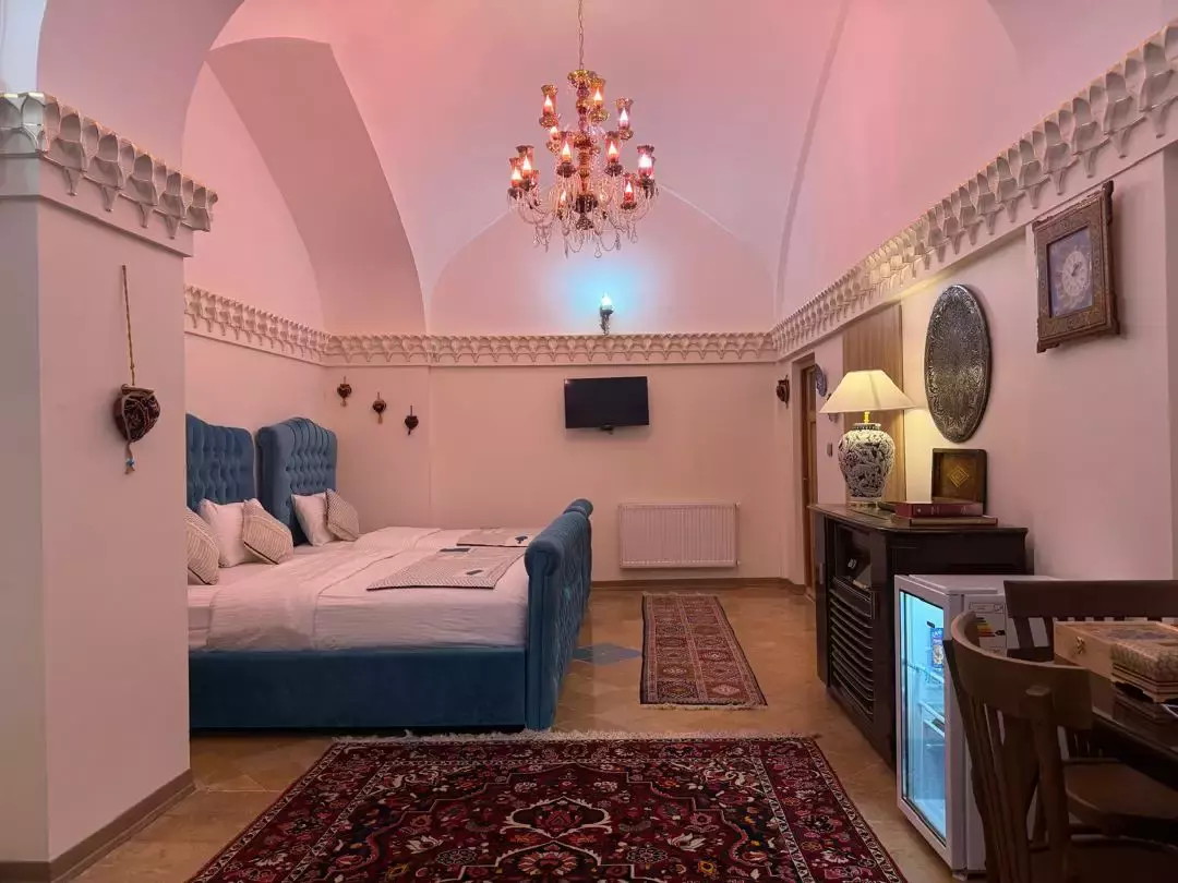 اتاق عمارت سهروردی با تخت آبی و فرش ایرانی