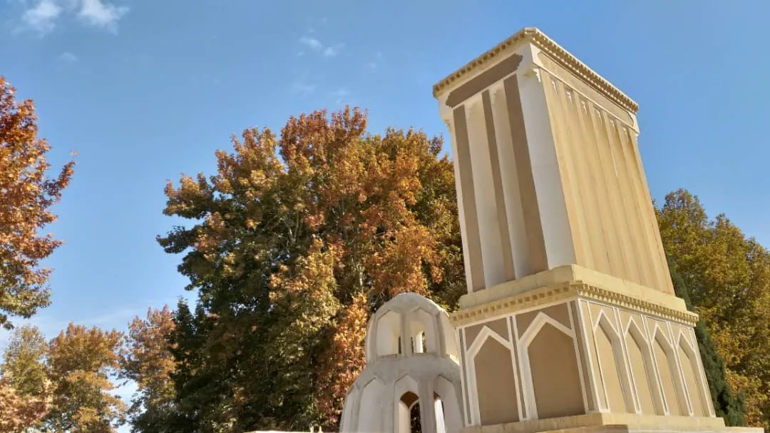 برج بلند باغ خوشنویس میان درختان پاییزی
