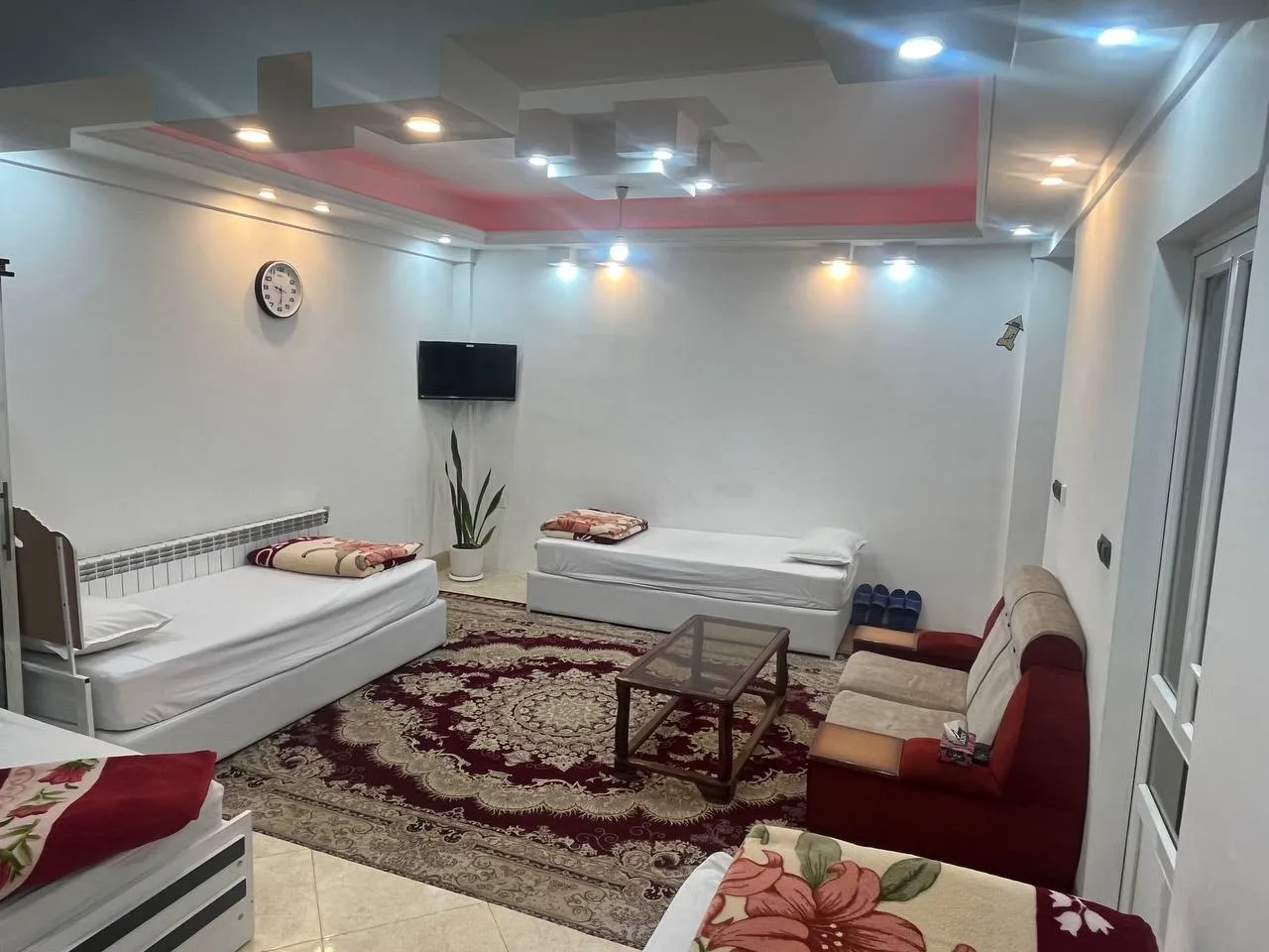 نشیمن اقامتگاه سهیل با تختهای یکنفره و فرش ایرانی