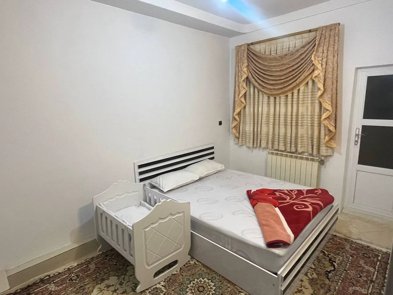 تخت اتاق هتل سهیل با تخت کودک کنار آن