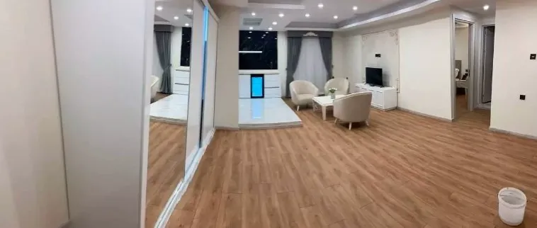 فضای نشیمن هیام با کفپوش چوبی و میز