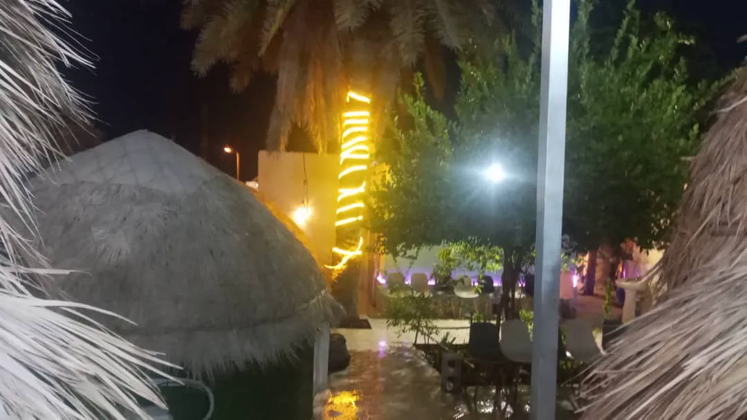 محوطه اقامتگاه دنج با کلبه‌های حصیری در شب