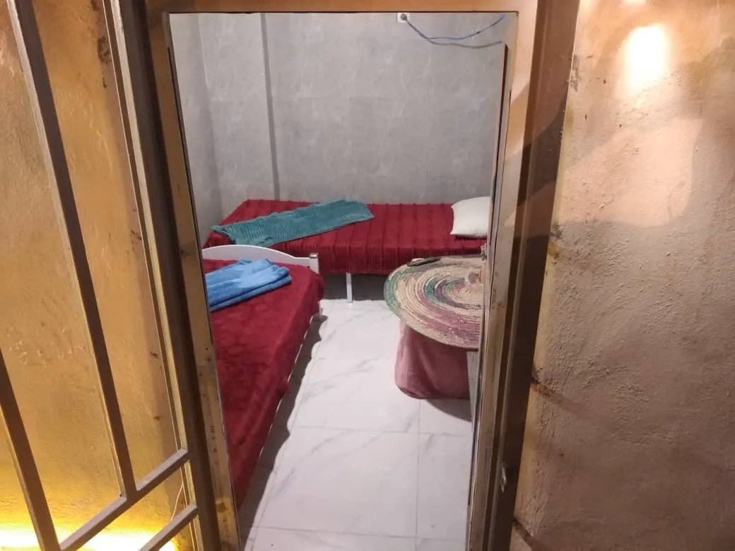 اتاق دنج با تخت‌های قرمز و میز گرد