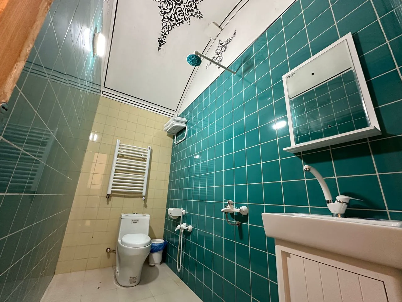 حمام عمارت ایرانی با کاشی‌های سبز و روشویی