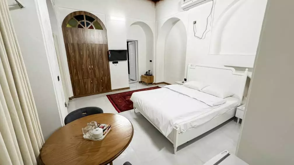 اتاق عمارت بیلیارد با تخت دونفره و طاقچه‌های قوسی
