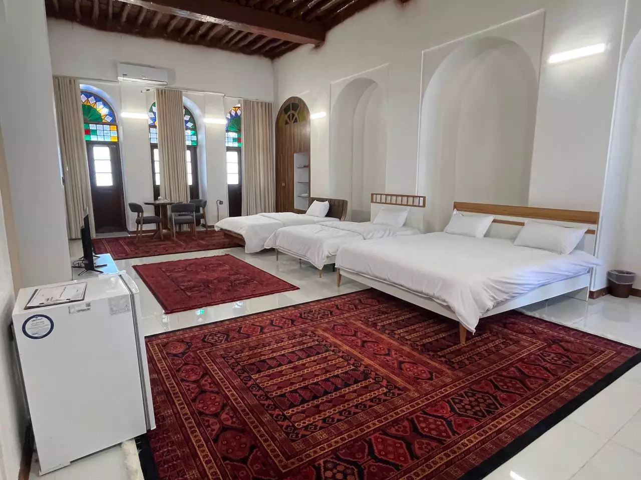اتاق عمارت بیلیارد با سه تخت و پنجره‌های رنگی
