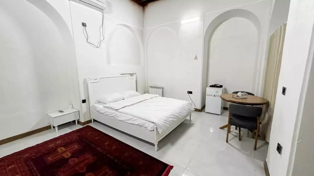 اتاق عمارت بیلیارد با تخت سفید و میز گرد