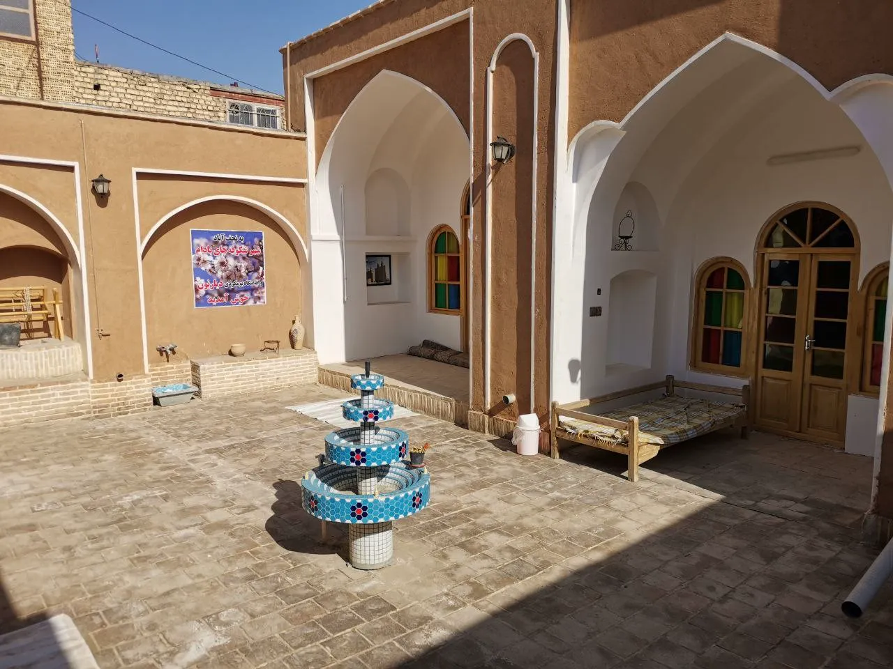 حیاط مرکزی مهمان‌پذیر دیارنون با حوض فیروزه‌ای