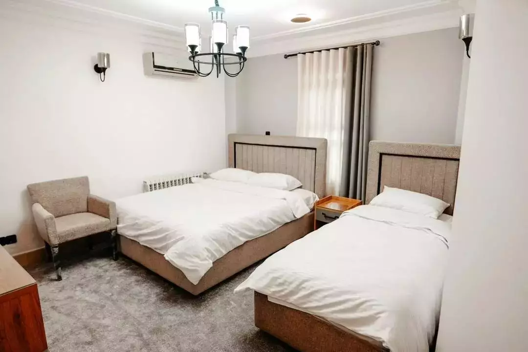 اتاق هتل کوثر با دو تخت و پنجره پرده‌دار
