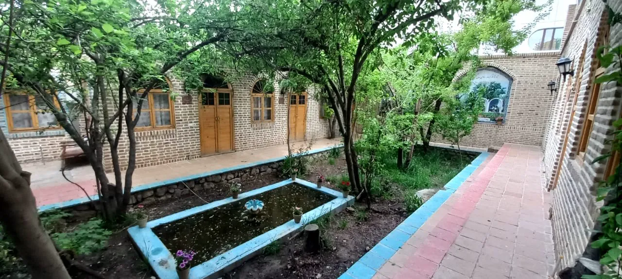حیاط سرسبز هتل شادمهر با حوضچه