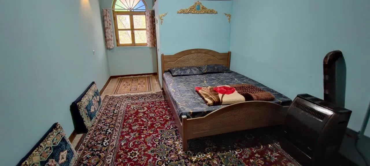 تخت چوبی و فرشهای سنتی در اتاق شادمهر