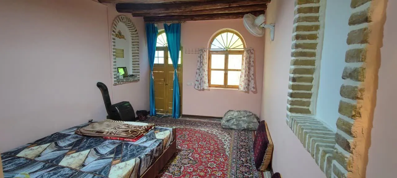 اتاق شادمهر با تخت، فرش دستباف و پنجره قوسی