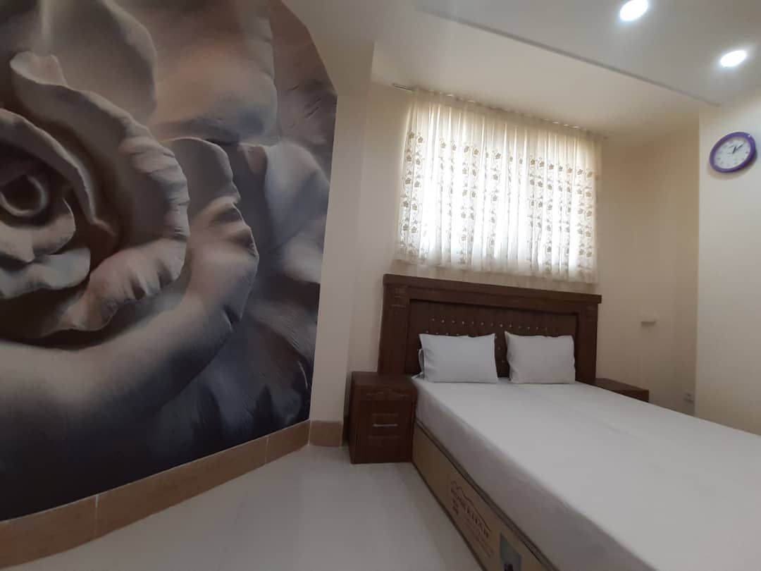 تخت دونفره کنار دیوارنگاره گل در خلف باغ یزد