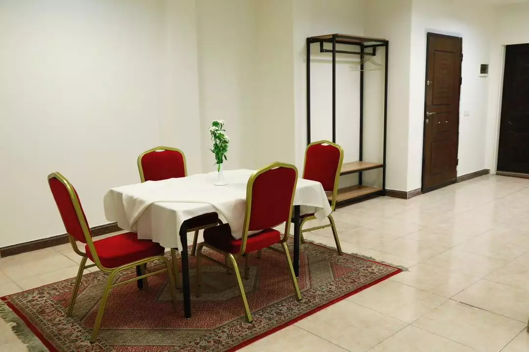 میز غذاخوری و صندلی‌های قرمز در پرشین پلازا مطهری