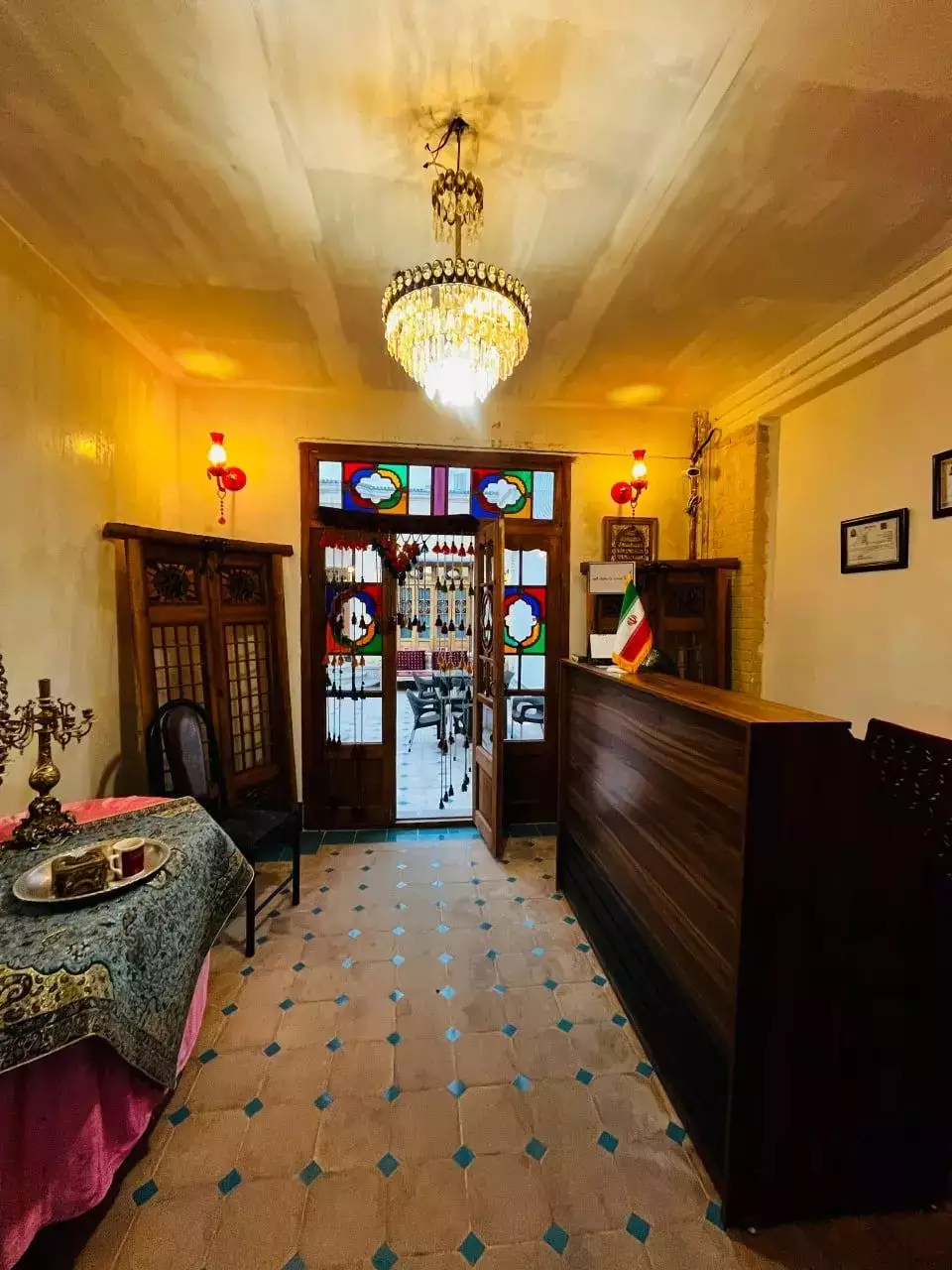 پذیرش هتل سلطانی با میز چوبی و لوستر چلچراغ