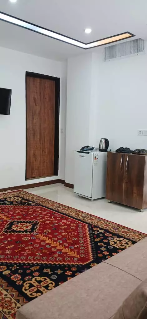 اتاق هتل الماس غرب با قالی قرمز و کمد چوبی