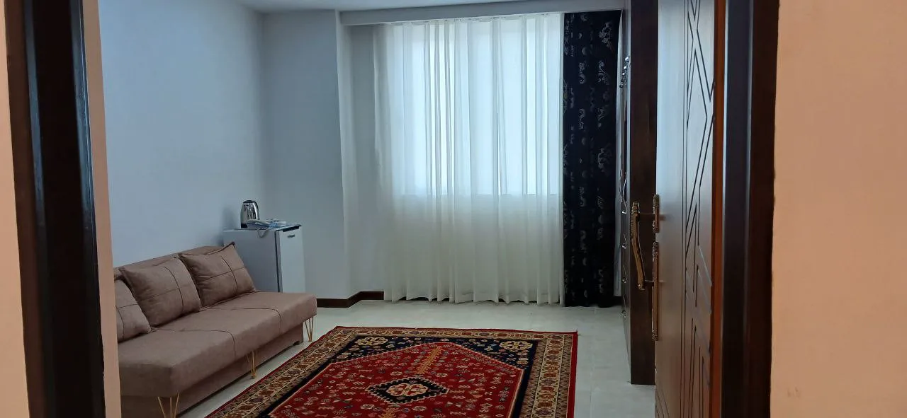 اتاق نشیمن هتل الماس غرب با کاناپه و پنجره پرده‌دار