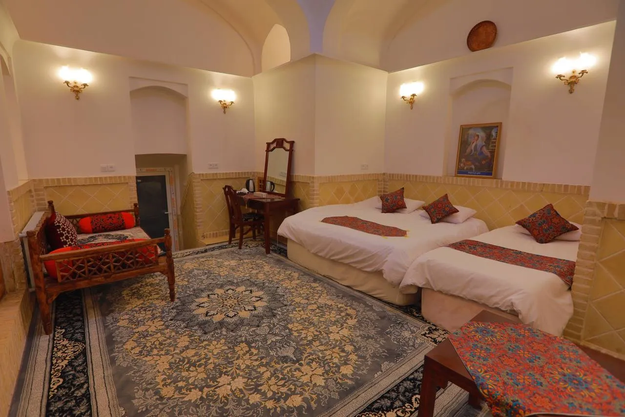 اتاق هتل باران با تختهای سنتی و فرش ایرانی
