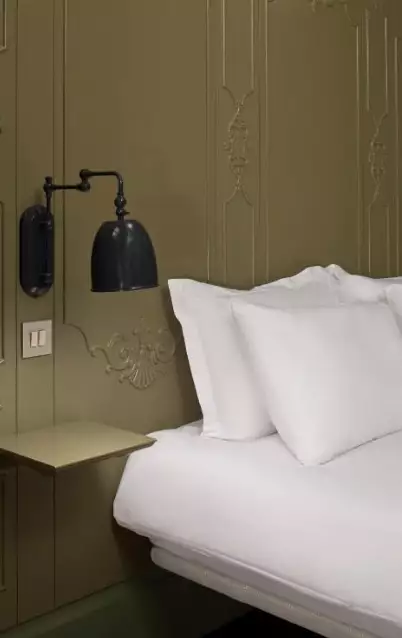 تخت سفید و چراغ دیواری اتاق هتل ستیا