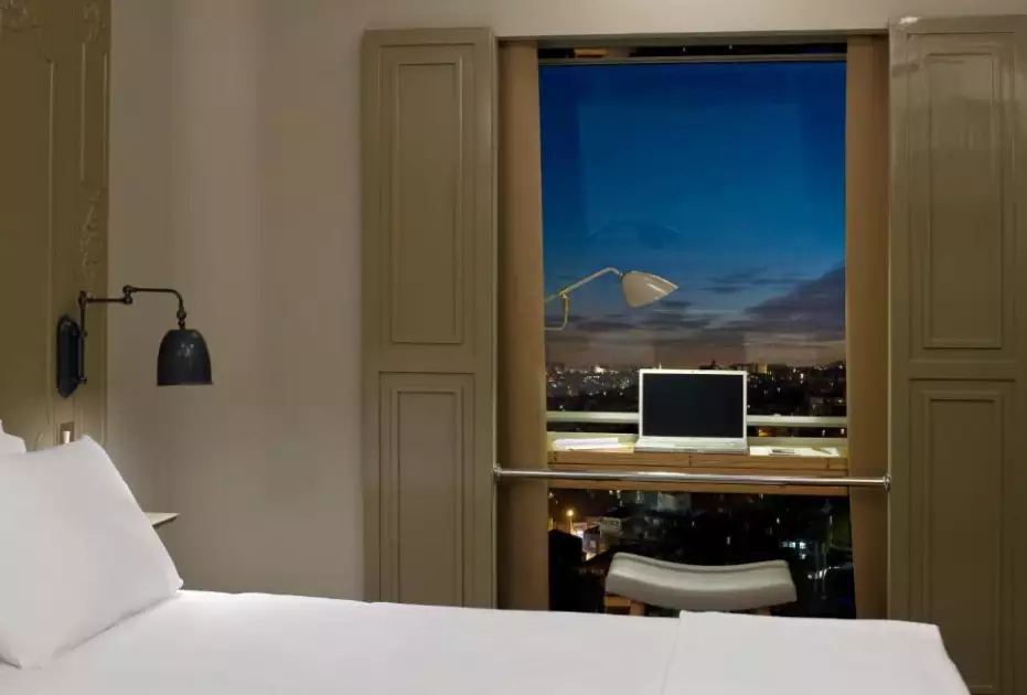 تخت و پنجره رو به شهر در هتل ستیا