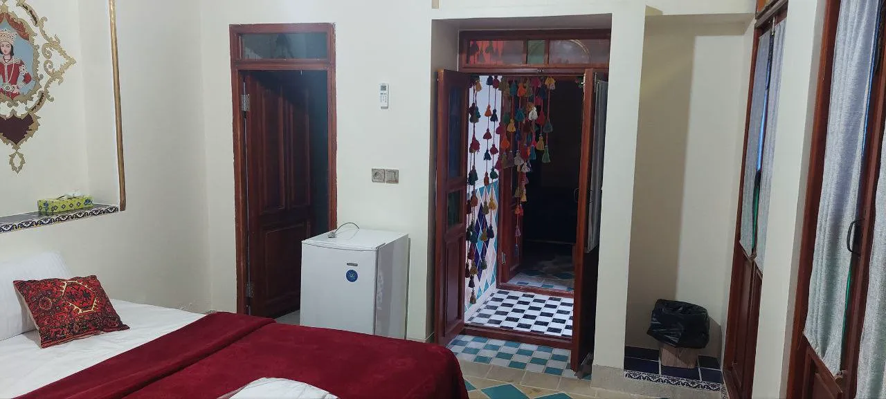 تخت اتاق اقامتگاه ملک تاج کنار مینی‌بار