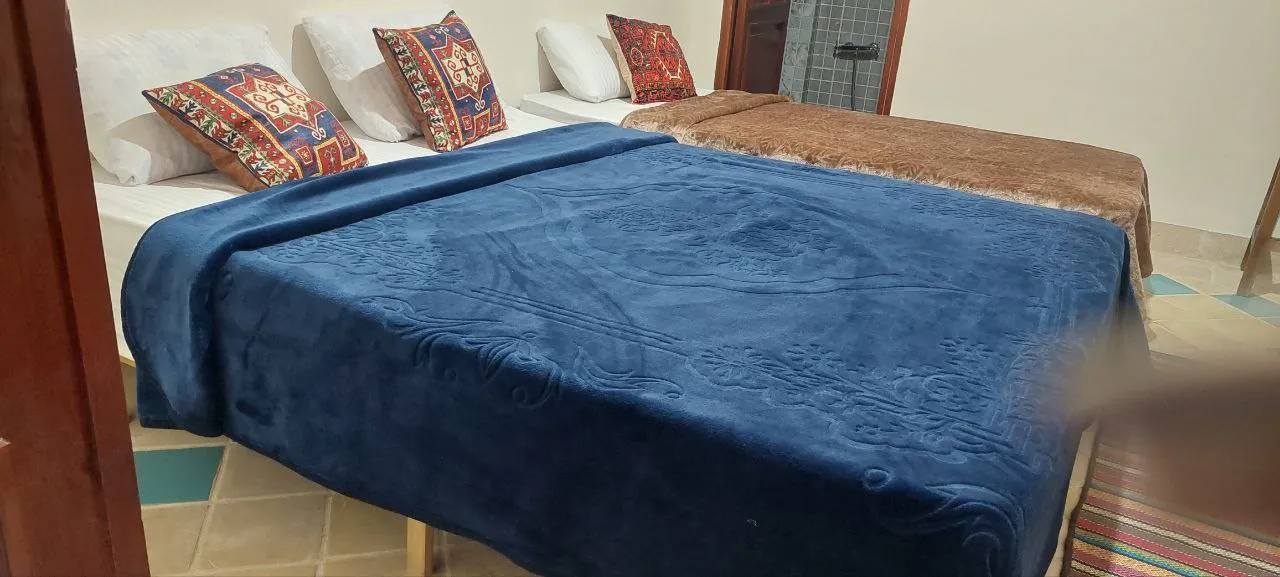 تخت دونفره با روتختی مخمل آبی در ملک تاج