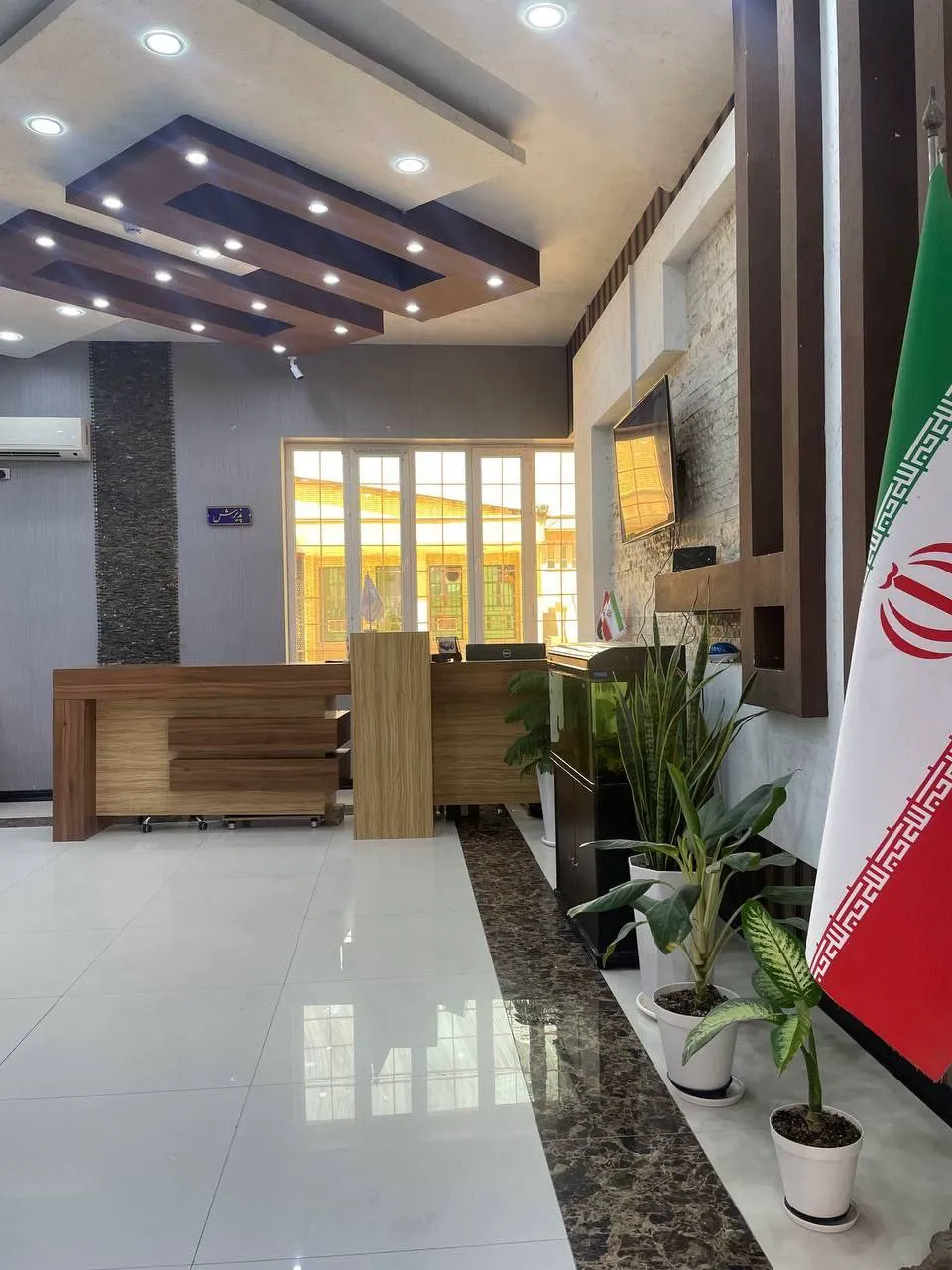 پذیرش هتل فرهیختگان با میز چوبی و پرچم ایران