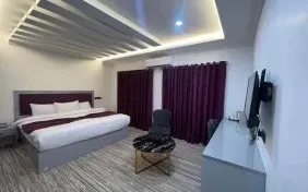 اتاق هتل بهشت با تخت دونفره و پردههای زرشکی