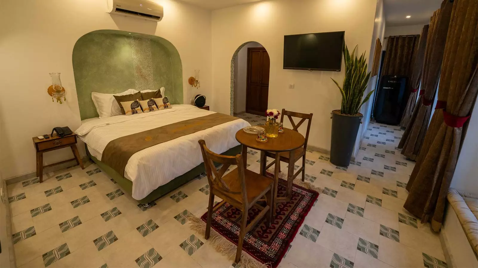 اتاق عمارت 85 با تخت دونفره و میز چوبی