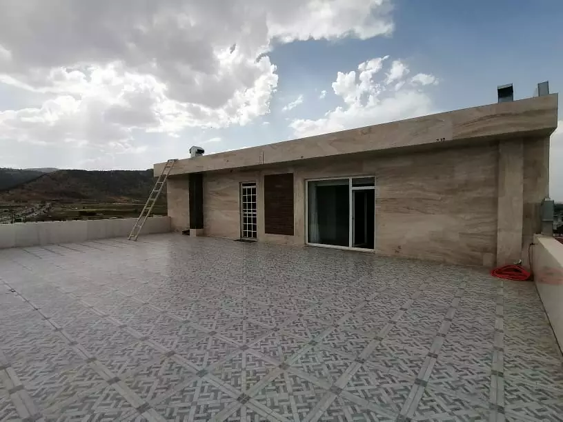 تراس سنگ‌فرش‌شده هتل تاراز با نمای کوهستان