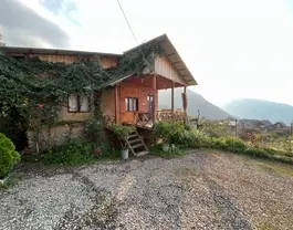 کلبه چوبی نماشان میان پوشش سبز کوهستان