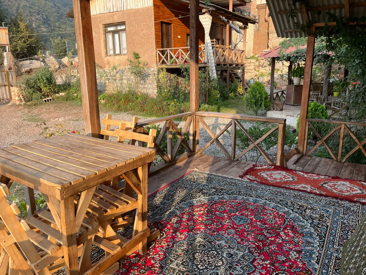 تراس نماشان با میز چوبی و فرش قرمز