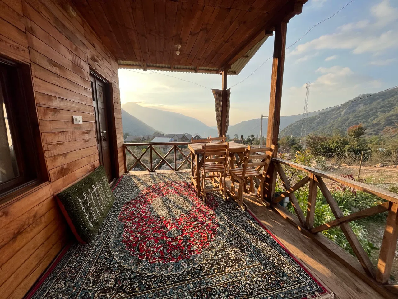 تراس چوبی نماشان با چشمانداز کوهستان در غروب