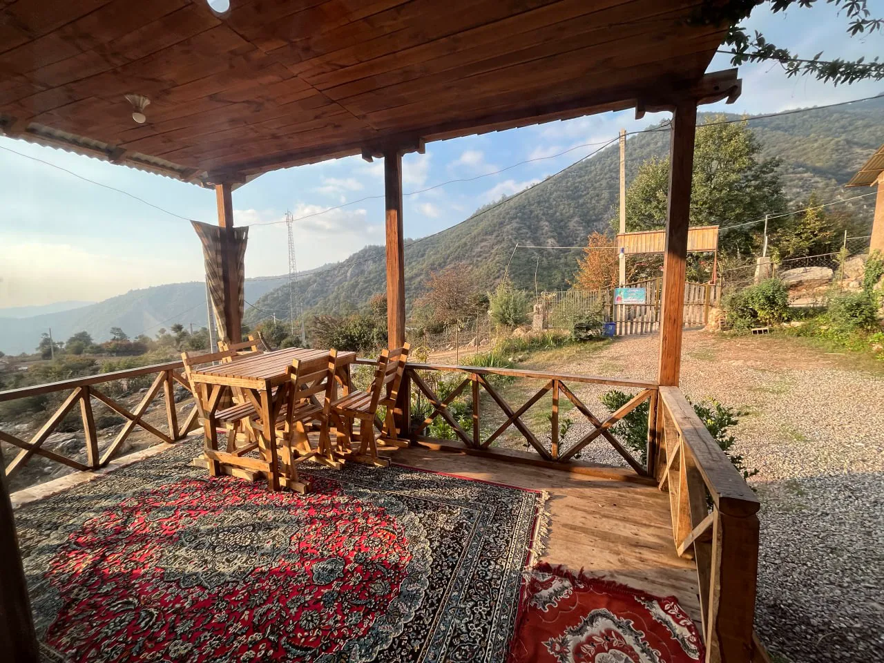 تراس چوبی نماشان با میز غذاخوری و فرش