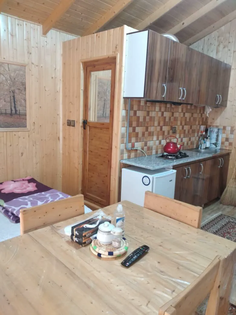 میز چوبی کنار آشپزخانه و تخت باغ ملک