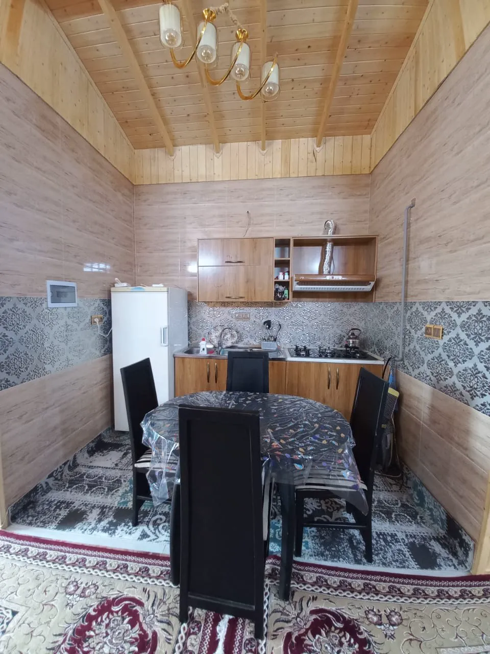 آشپزخانه با میز غذاخوری در باغ ملک