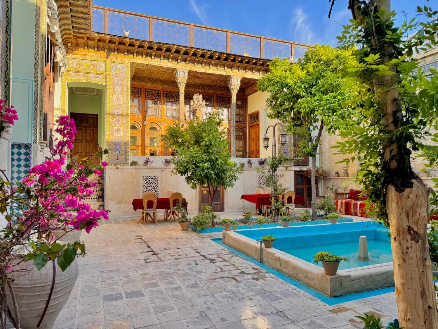 حیاط خانه با حوض آبی و ایوان ستون‌دار