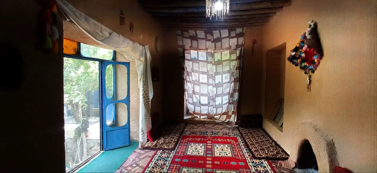 اتاق سنتی شاه رستم با فرش دست‌باف و در آبی