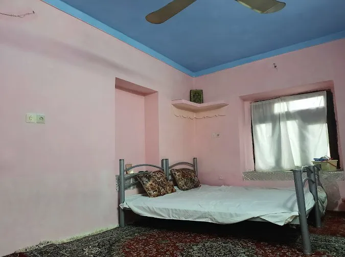 اتاق چشمه سعدی با تخت فلزی و دیوارهای صورتی