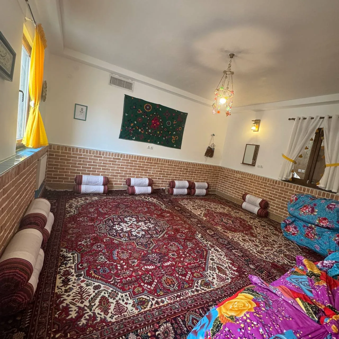 اتاق سنتی با فرش ایرانی و پشتی در هتل گلجان