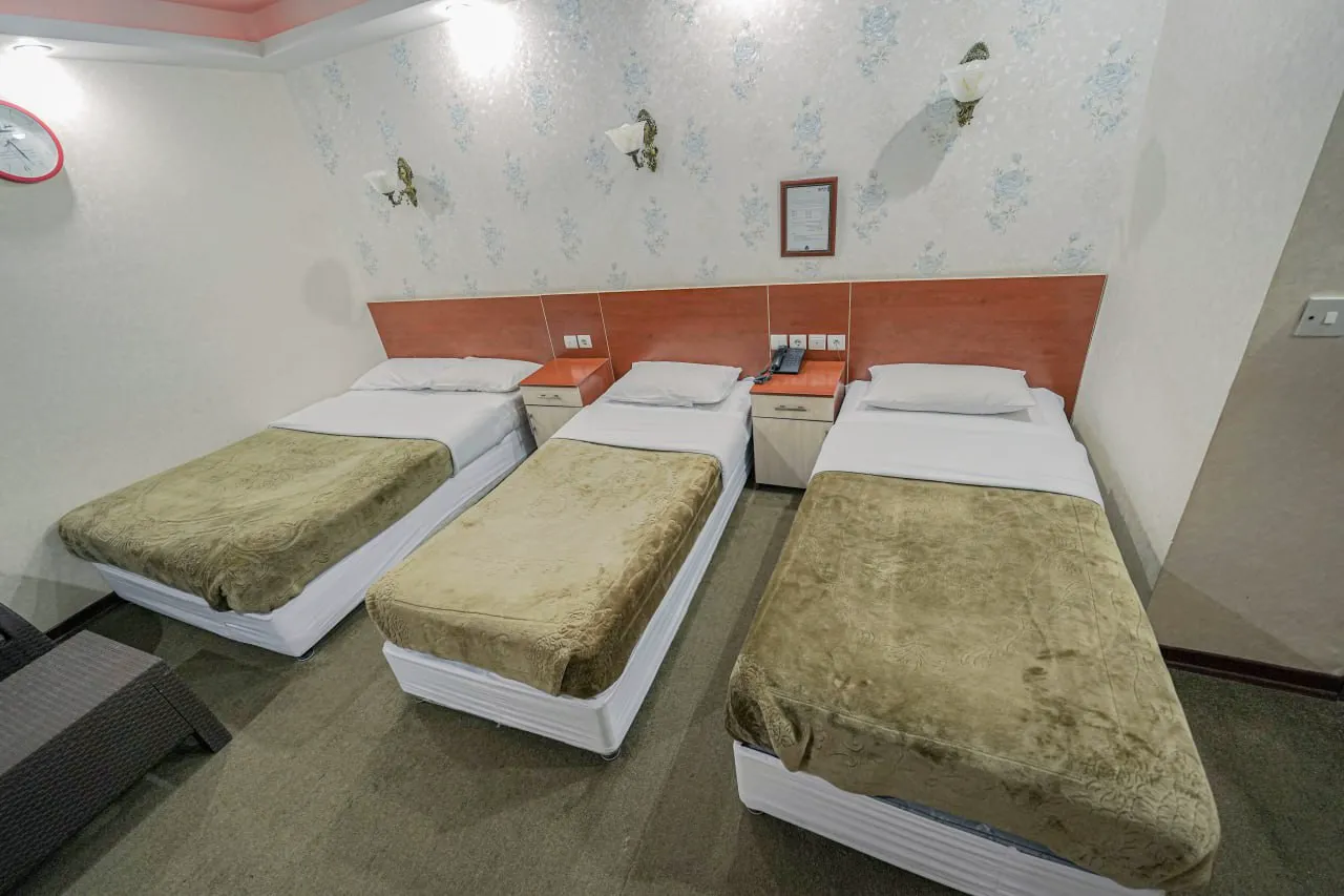 سه تخت یک‌نفره در اتاق هتل ایران