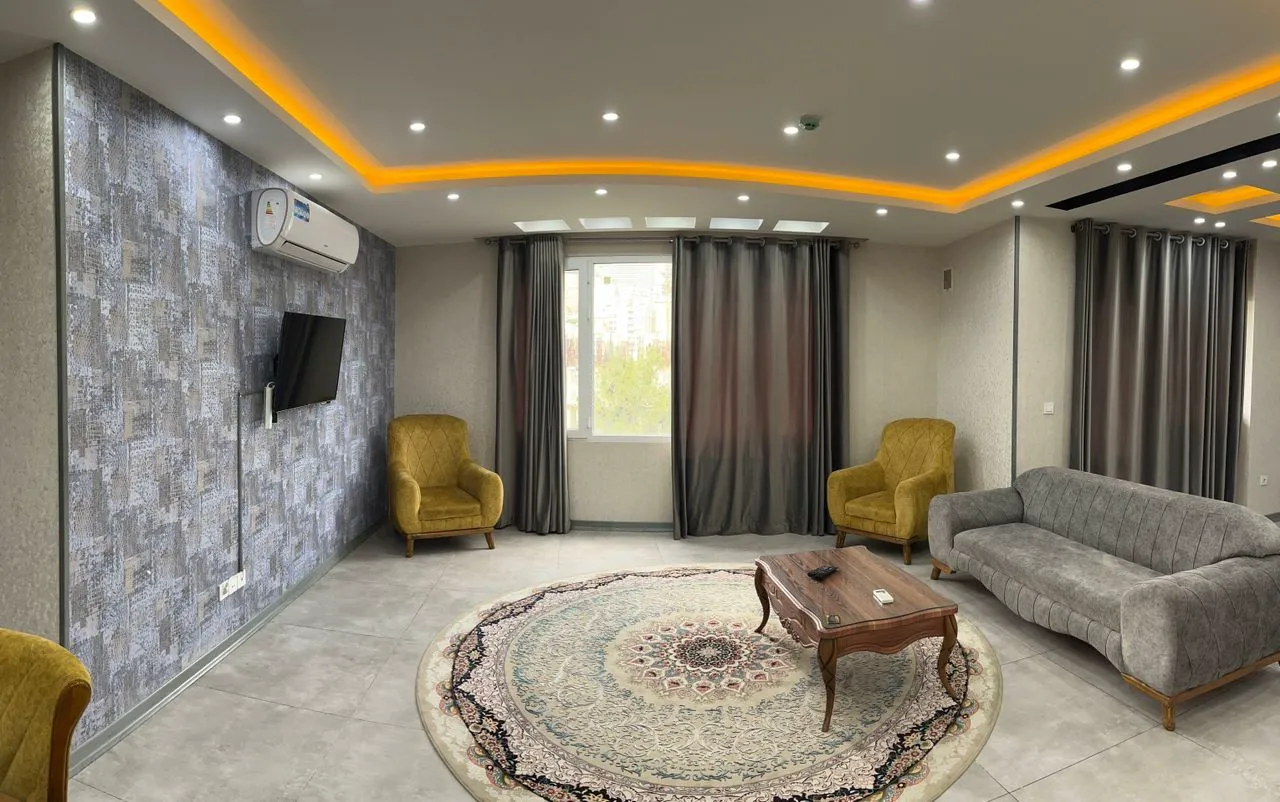 پذیرایی آویسا با مبل خاکستری و دو صندلی زرد