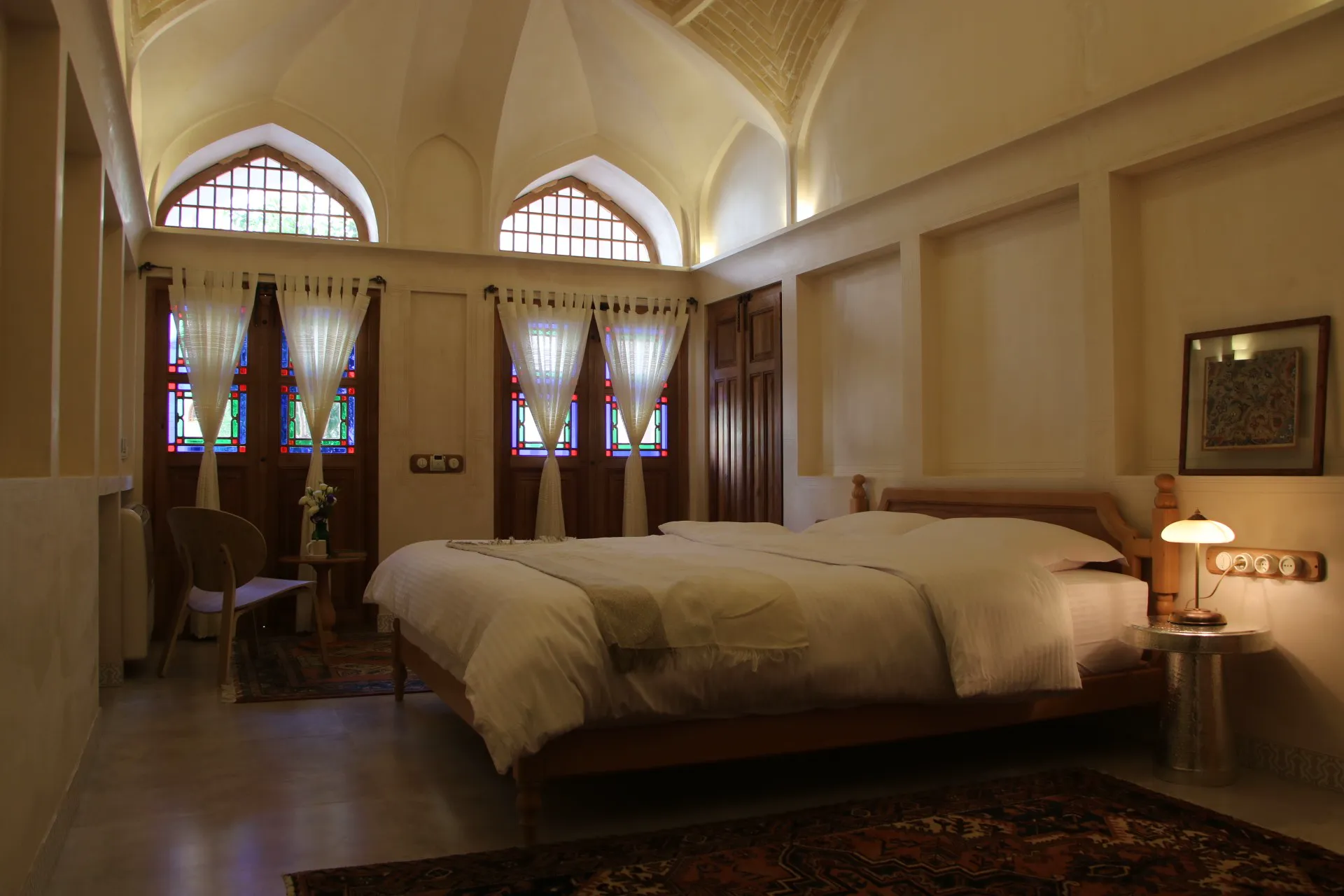 اتاق عمارت بالابان با پنجره‌های رنگی قوسی