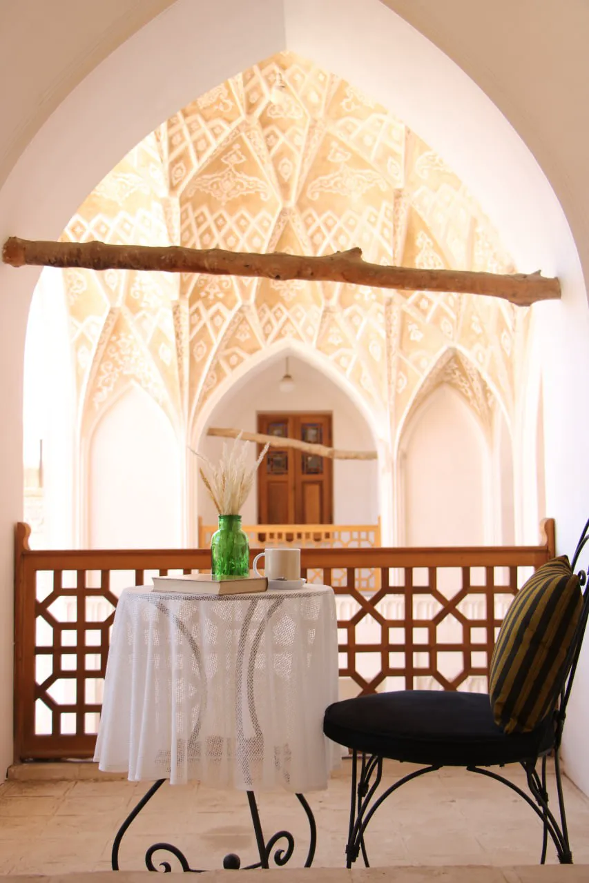 میز و صندلی در ایوان قوس‌دار عمارت بالابان