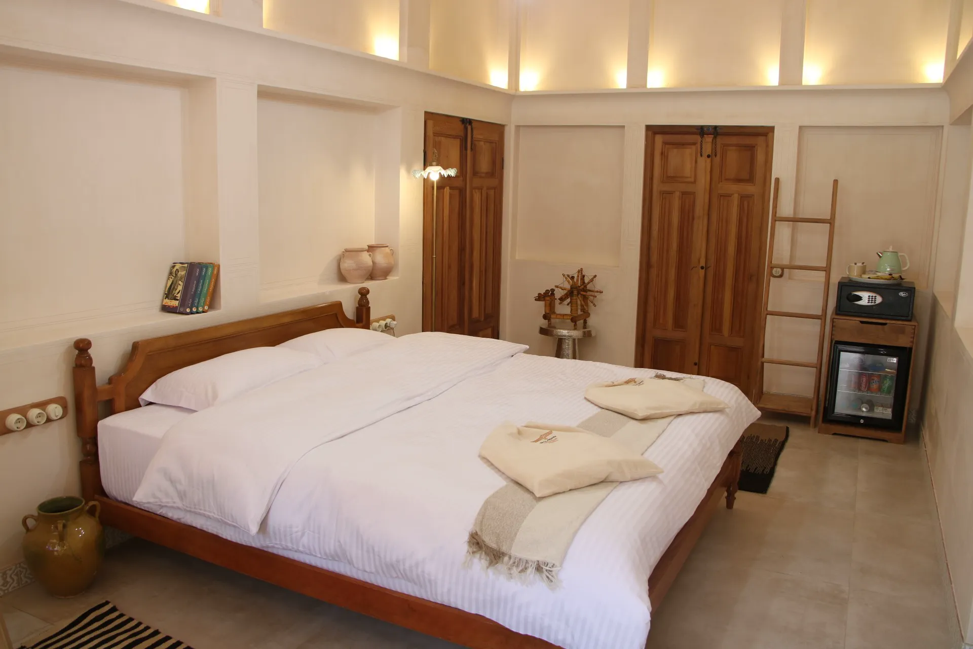 اتاق عمارت بالابان با تخت چوبی و یخچال