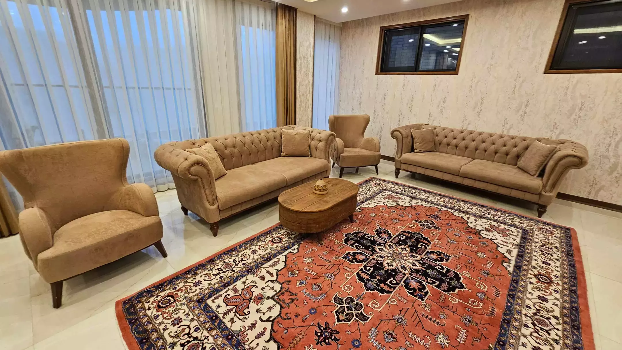نشیمن هتل مُلک قدوس با مبلمان کرم و فرش قرمز