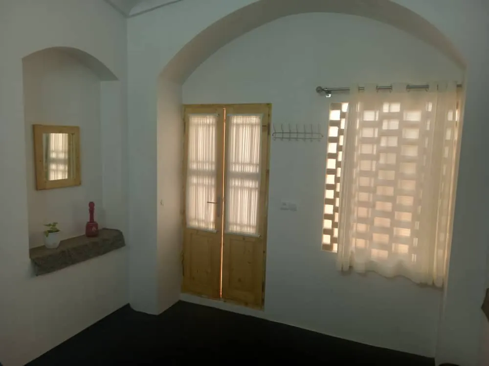 پنجره و در چوبی در اتاق هتل بمانی