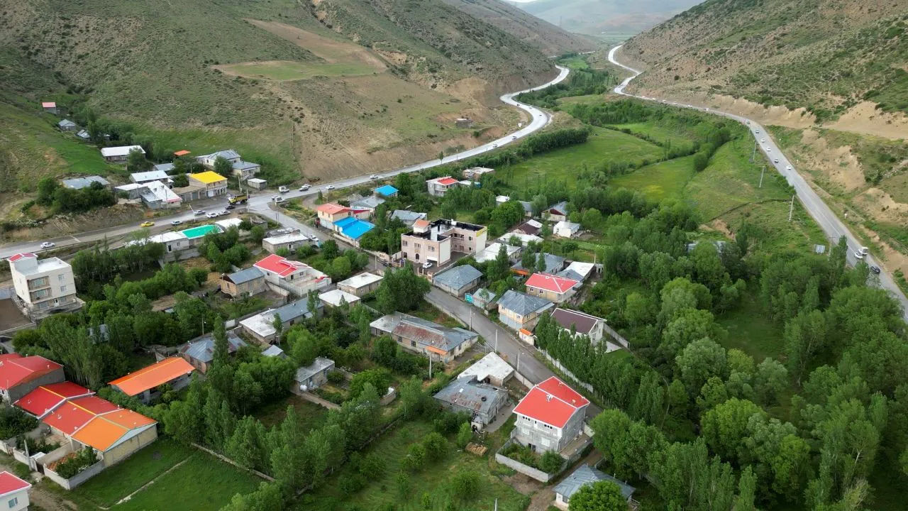 نمای هوایی روستای سرسبز و خانههای پراکنده