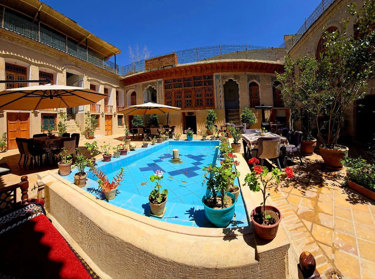 حیاط عمارت جهانشاهی با حوض آبی و گلدانها